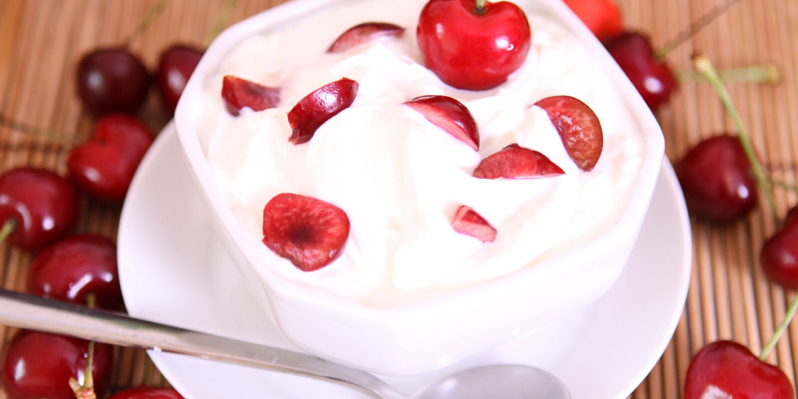 Quark in einer Schüssel angerichtet mit Kirschen